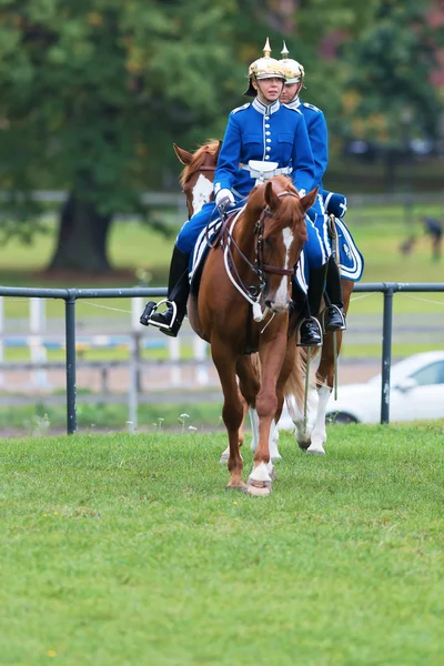 Stockholm - sep, 22: twee renners met zilveren helm en zwaard uit de gekoppelde guard de arena in de gekoppelde bewaker gebeurtenis invoeren voor het publiek in ryttarstadion sep 22, 2013 in stockholm, Zweden — Stockfoto