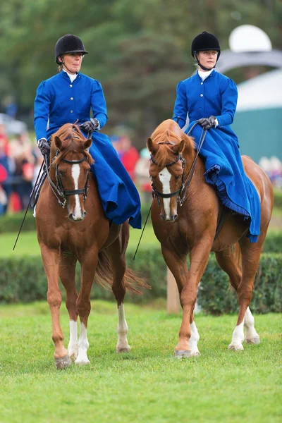 STOCKHOLM - 22 SETTEMBRE: Due donne della Blue Star in sella al sidesaddle all'evento The Mounted Guard per il pubblico a Ryttarstadion 22 settembre 2013 a Stoccolma, Svezia — Foto Stock