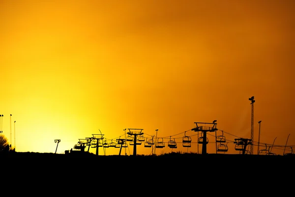 Ski lift silhouette with yellow sky — Stock Photo, Image