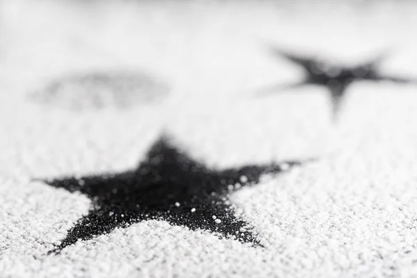 Black star on white sugar — Stock Photo, Image
