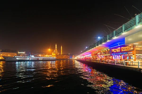 Galata Köprüsü'nde balıkçılar yukarıda ve neon ışıkları ile güverte altında restoranlar — Stok fotoğraf