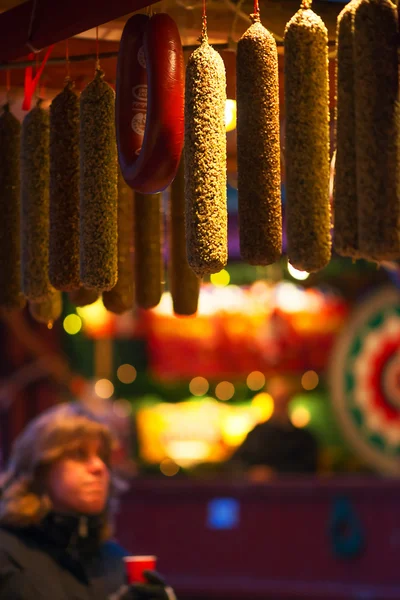 A woman looking at smoked sausages at Stortorget Christmas market in Stockholm — Stock Photo, Image