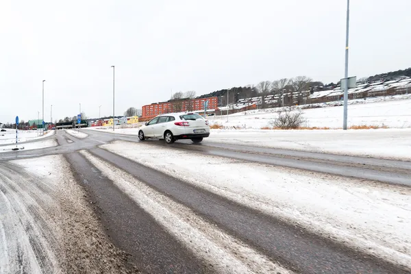 Carro ao longo da estrada lamacenta e nevada — Fotografia de Stock