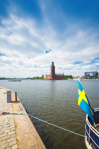 Stadshuset tarafından geçen bir vapur ve İsveçli bir bayrak ile — Stok fotoğraf