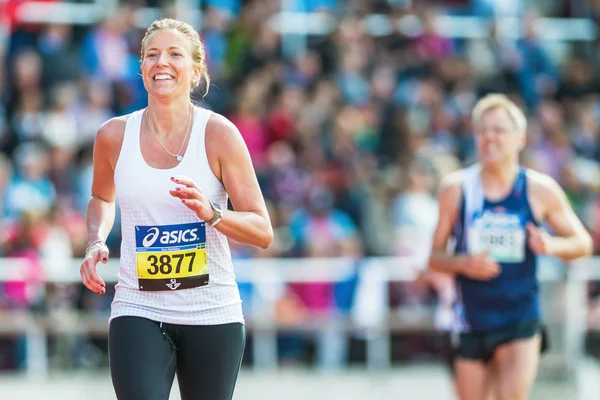 Szőke nő fut az utolsó szakaszon a stockholm stadion — Stock Fotó