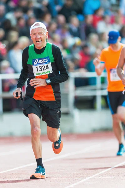 Older man running the final stretch at Stockholm Stadion — Stock Photo, Image
