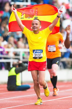 çalışan ve İspanyol bayrağı sallayarak mutlu bir İspanyol adam