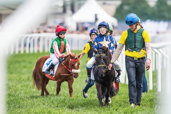 Pony racers warming up with their trainers and horses before the — Stock Photo, Image