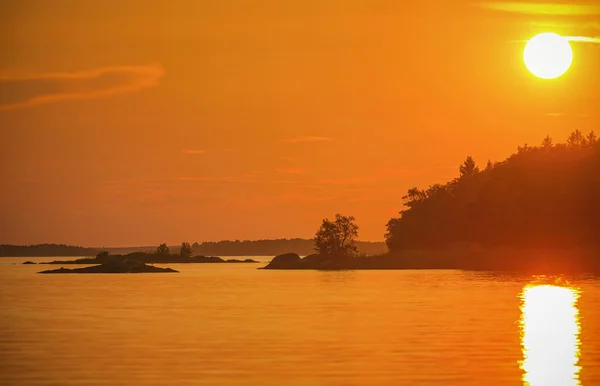 Puesta de sol en una costa con pequeñas islas — Foto de Stock