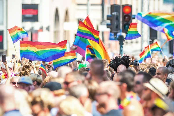 mutlu insanlar stockholm gurur geçit töreninde gökkuşağı bayrakları sallayarak