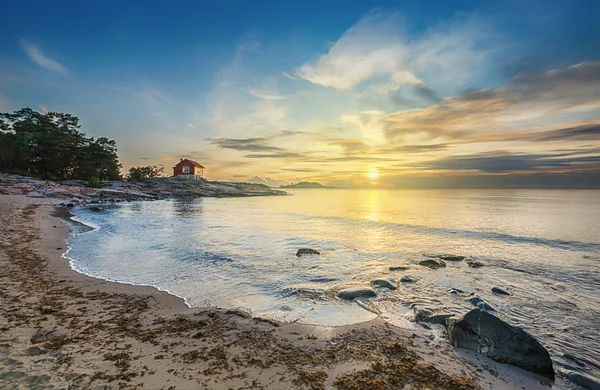 Czerwony domek nad samym brzegiem morza w sunrise — Zdjęcie stockowe