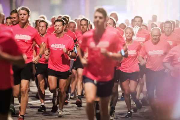 Primer plano de los corredores en uno de los muchos grupos de la carrera de medianoche —  Fotos de Stock