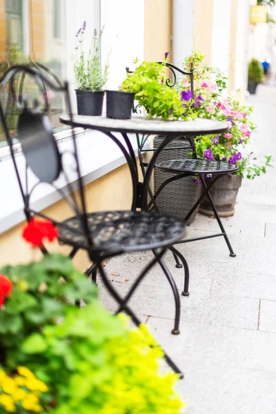 Vintage coffee table with chairs and colorful flowers on a street. Tallinn, Estonia