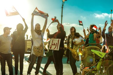 Mısırlı kız bayrakları ve bırakın işareti ile protesto