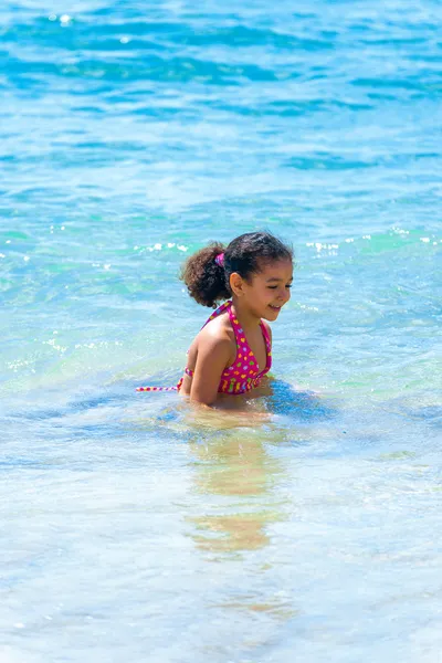 Liten flicka som leker i havet bevattnar — Stockfoto