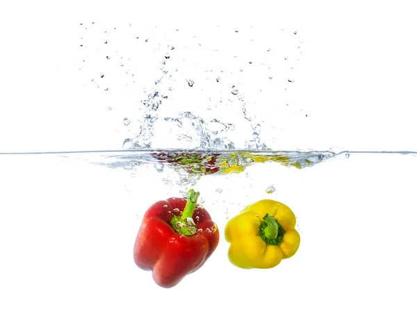 Färsk röd och gul paprika frukt plaska i vatten — Stockfoto