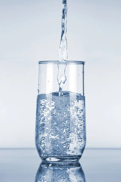Вода наливається в склянку — стокове фото