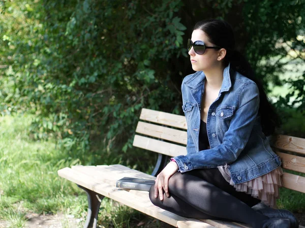 Mulher sentada no banco do parque — Fotografia de Stock