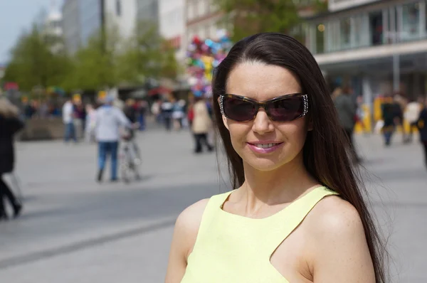 Femme d'âge moyen avec des lunettes de soleil dans la rue piétonne — Photo
