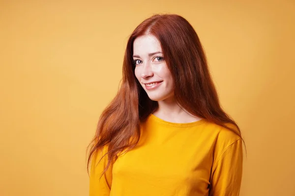 Boldog fiatal nő hosszú vörös hajjal mosolyog — Stock Fotó