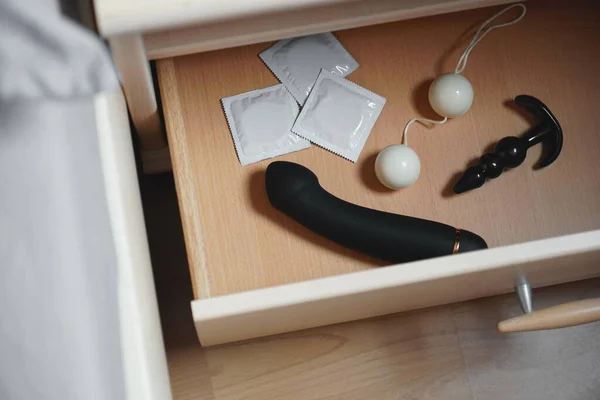 Adult toys and condoms in bedside table or nightstand drawer — Stock Photo, Image