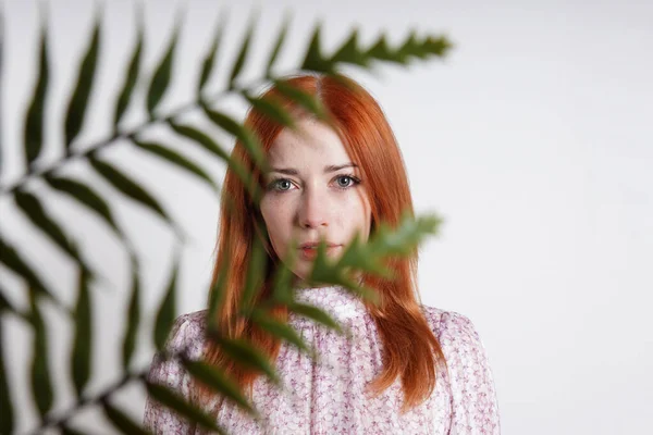 Mid adult woman hiding behind house plant palm leaves — ストック写真