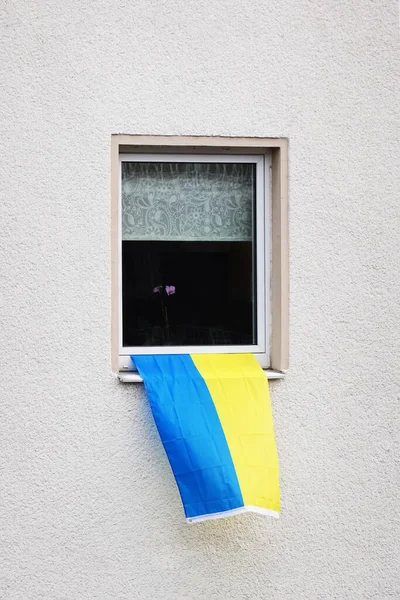 Flag of ukraine hanging from window of residential building — Photo