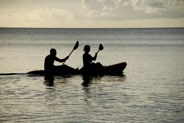 Silhouetted kayakers on the ocean — Stock Photo, Image