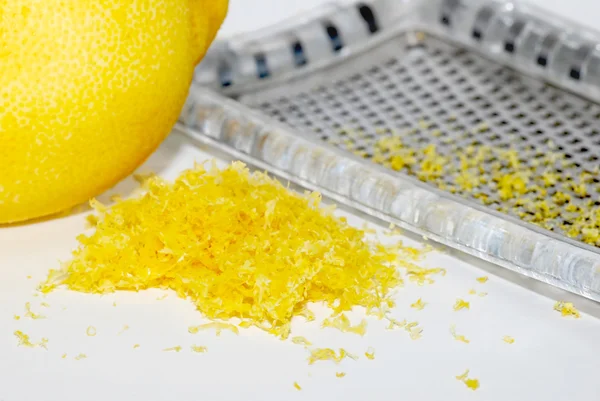 Grated lemon zest with the fruit and grater — Stock Photo, Image