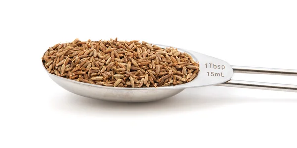 Cumin seeds measured in a metal tablespoon — Stock Photo, Image