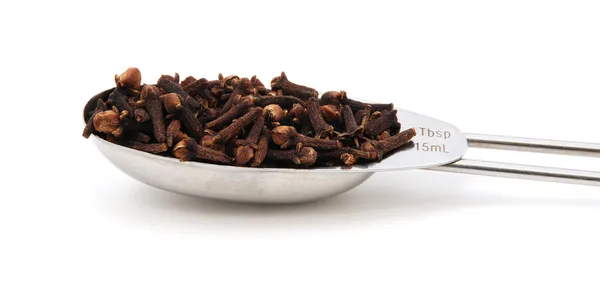 Whole cloves measured in a metal tablespoon — Stock Photo, Image