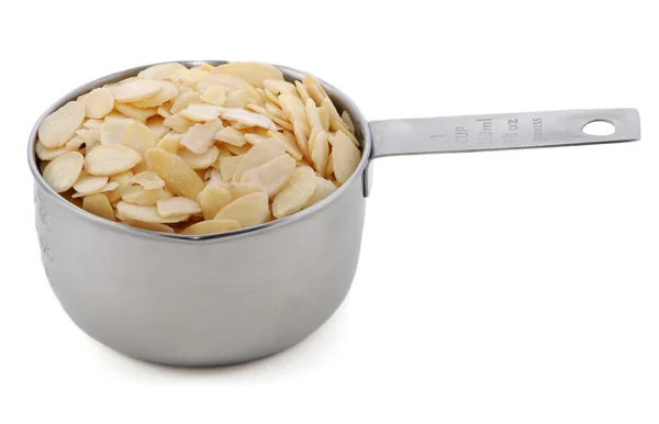 Flaked almonds presented in an American metal cup measure — Stock Photo, Image