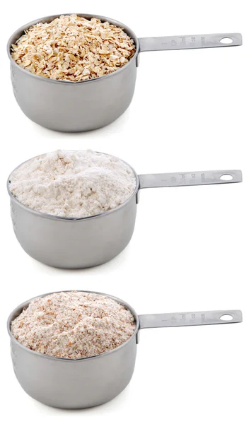 Everyday staple ingredients - rolled oats and flours - in cup measures — Stock Photo, Image