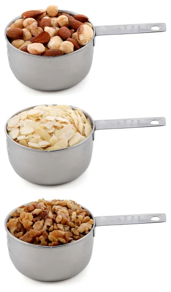 Whole hazelnuts, flaked almonds and chopped walnuts in cup measures — Stock Photo, Image