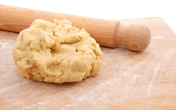 Wooden rolling pin and a fresh ball of pastry on a floured board — Stock Photo, Image