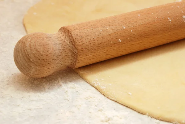 Detail of a wooden rolling pin on rolled out pastry — Stock Photo, Image