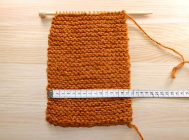 A length of knitting being measured in centimetres clipart