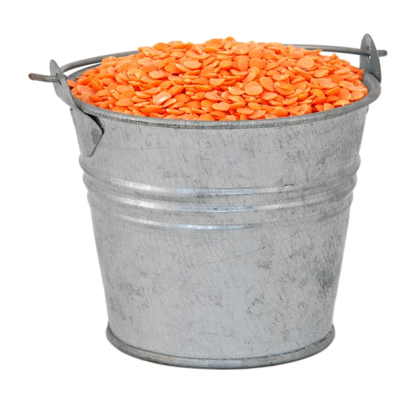 Red lentils in a miniature metal bucket — Stock Photo, Image