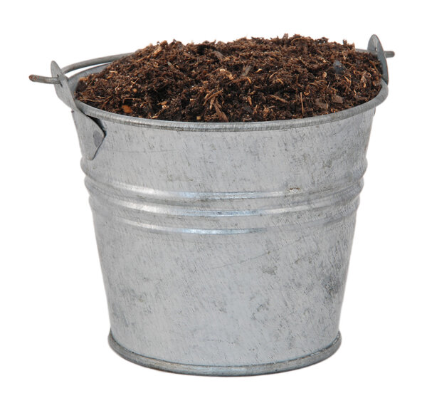 Compost, soil or dirt in a miniature metal bucket