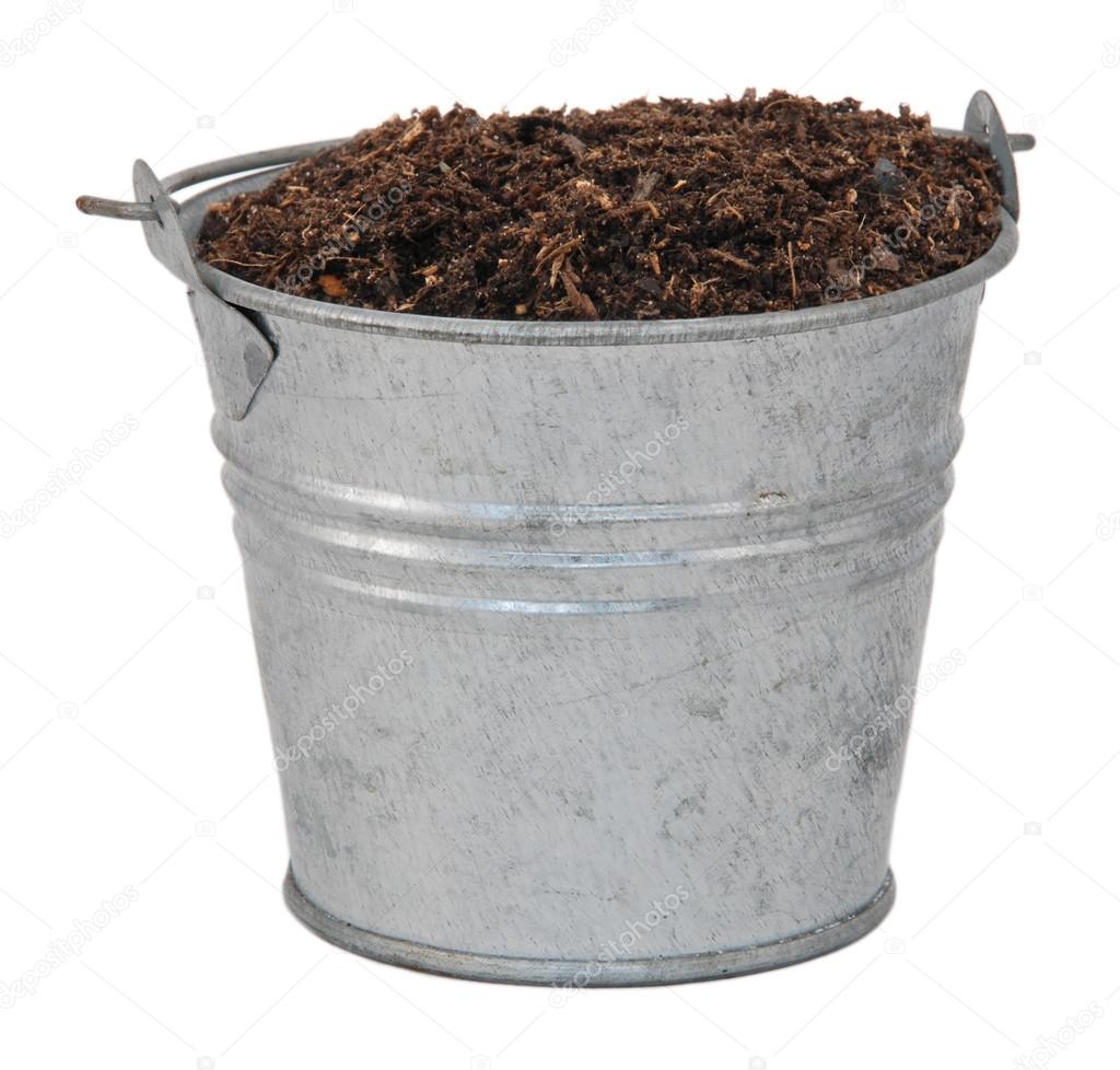 Compost, soil or dirt in a miniature metal bucket