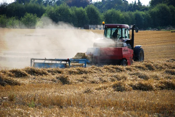 Traktor ballt Stroh auf einem Feld — Stockfoto