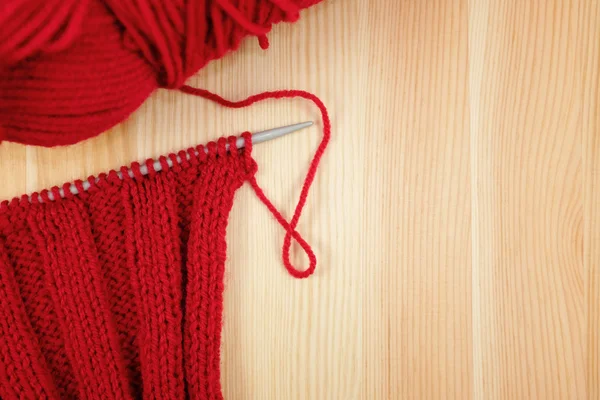 Red knitting in rib stitch with a ball of yarn — Stock fotografie