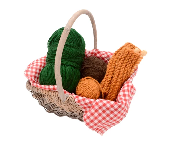 Green, brown and orange yarn with knitting in a basket — Stock Photo, Image