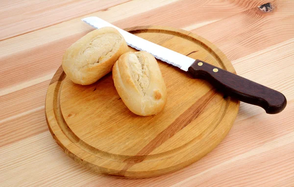 Closeup of two fresh petit pain with a bread knife — Stock Photo, Image
