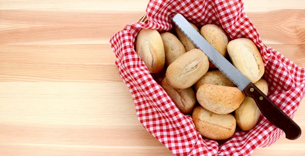 Basket of petit pain and a bread knife — Stock Photo, Image