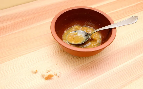 Empty bowl of soup with bread crumbs on the table — Stock Photo, Image