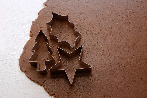 Cutting out Christmas shapes from gingerbread dough — Stock Photo, Image