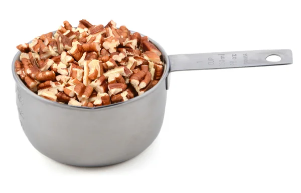 Nueces de pacana picadas en una medida de taza de metal — Foto de Stock