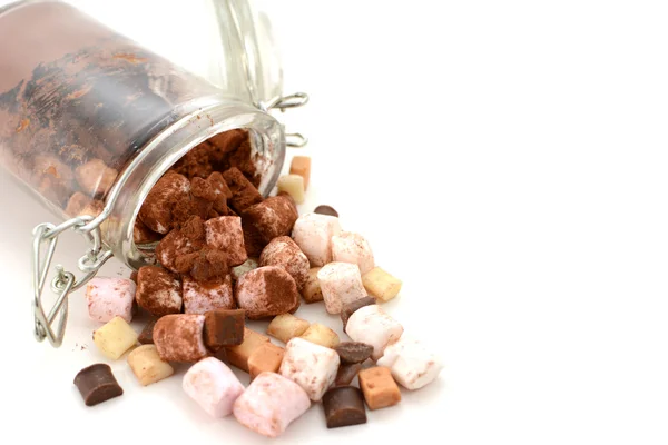 Cocoa and hot chocolate toppings spill from a glass jar — Stock Photo, Image