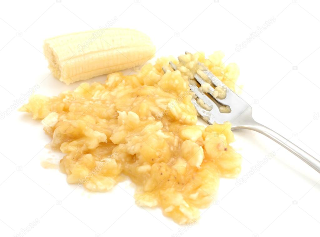 Closeup of mashed and whole banana with a fork
